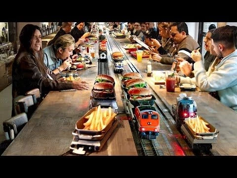 Inside Futuristic Restaurant Serving Burgers with Tiny Trains